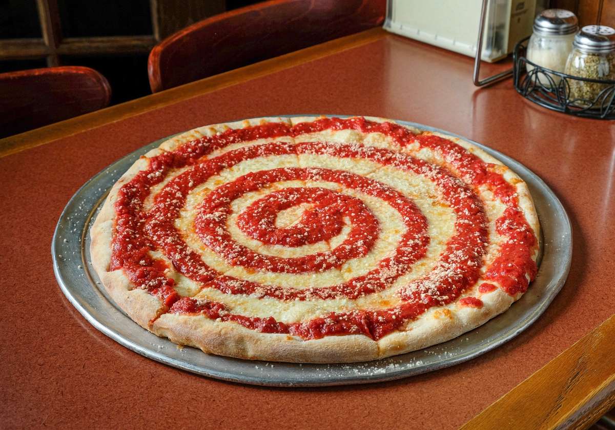 A spiral pizza sitting on a table.