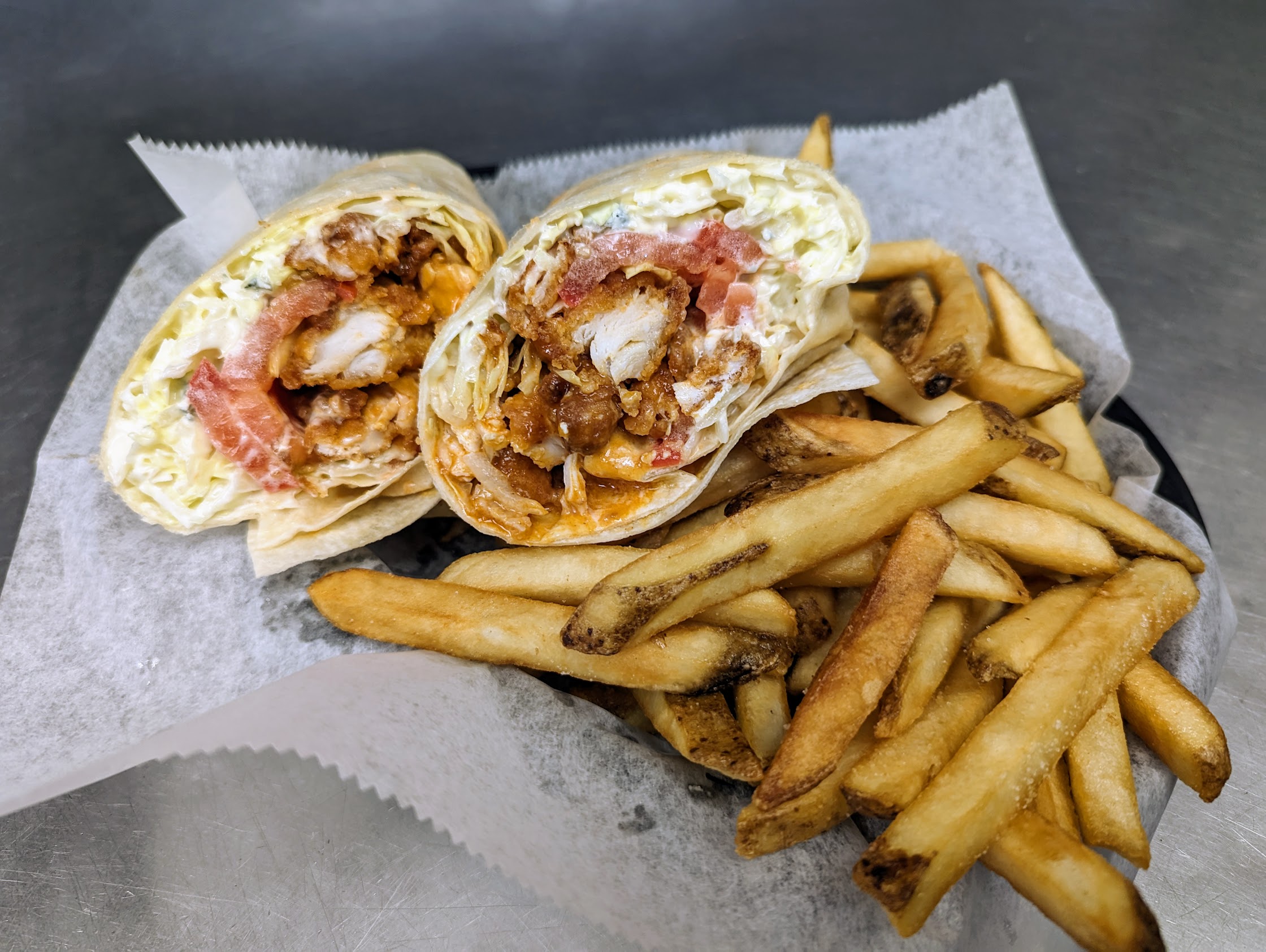 A burrito with french fries on a plate.